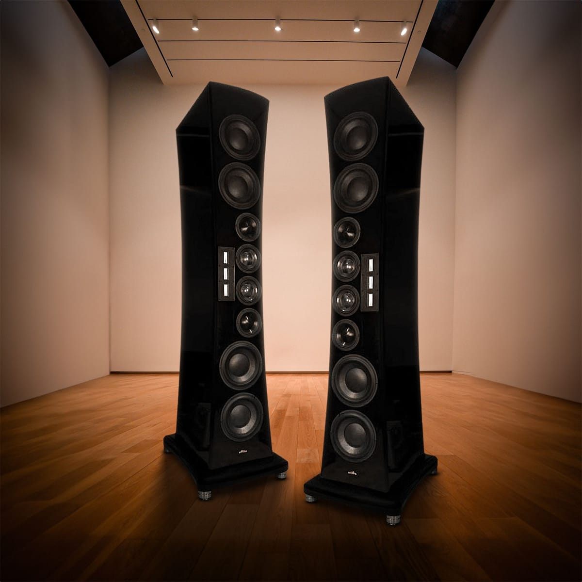 A pair of Reference Tower loudspeakers standing in a gallery style room with track lighting and a wood floor